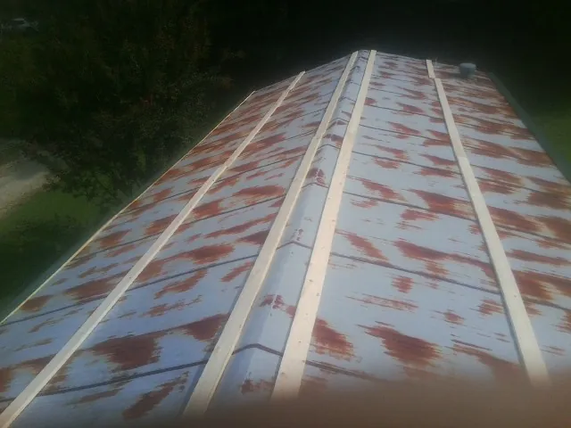 Rusted metal roof panels with new wood purlins before replacement — Storm Damage Roof Repair in Orangeville by Roofing Brothers